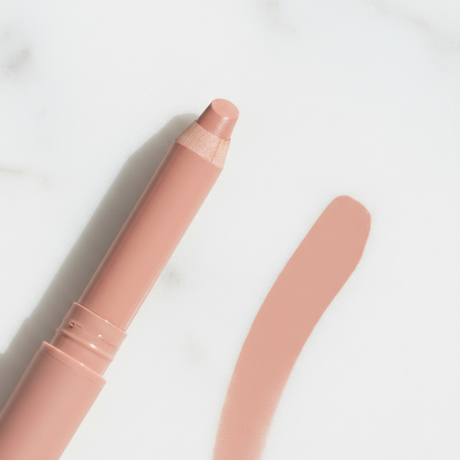 Close-up of retractable lip liner pencil tip and twist-up mechanism on white marble