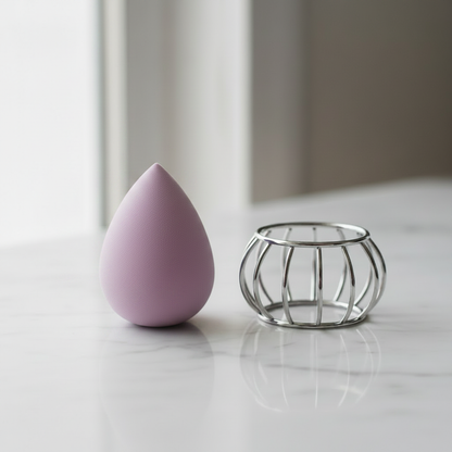 Lavender Purple teardrop makeup sponge beside silver wire cage holder on white marble